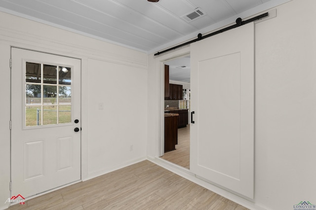 interior space with a barn door and light wood-type flooring