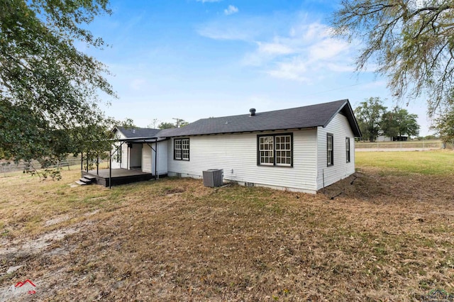 back of property with a yard and central air condition unit