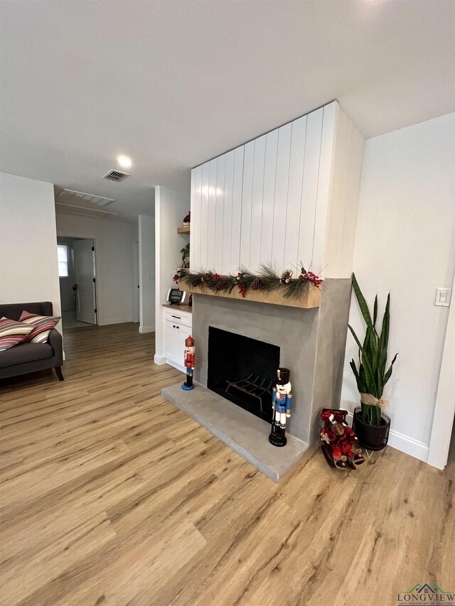 7 Rockwall Dr, Longview, TX 75604 - living room with light wood finished floors, a fireplace with raised hearth, and baseboards