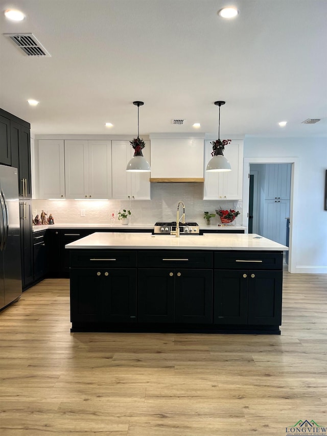 7 Rockwall Dr, Longview, TX 75604 - kitchen with freestanding refrigerator, dark cabinets, light countertops, a kitchen island with sink, and recessed lighting