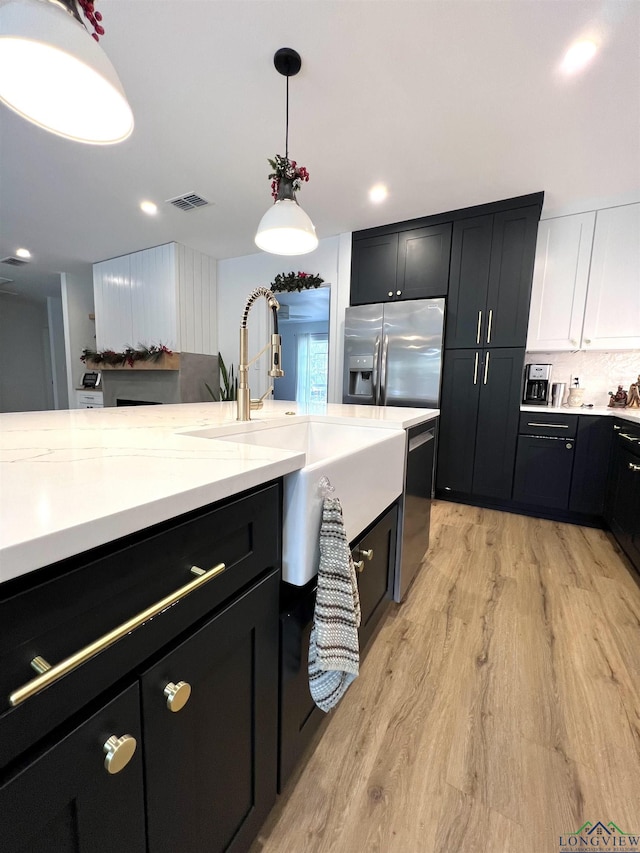 7 Rockwall Dr, Longview, TX 75604 - kitchen featuring stainless steel appliances, a sink, light wood-style floors, dark cabinetry, and recessed lighting