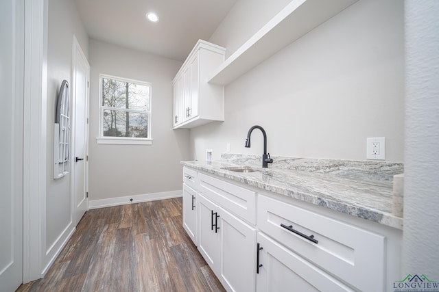 laundry room featuring hookup for a washing machine, sink, dark wood-type flooring, and cabinets