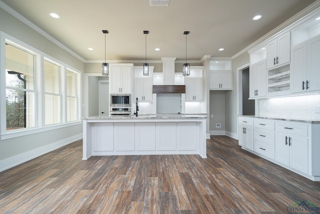 kitchen with hanging light fixtures, an island with sink, appliances with stainless steel finishes, and white cabinets