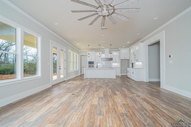 unfurnished living room featuring crown molding, ceiling fan, sink, and light hardwood / wood-style flooring