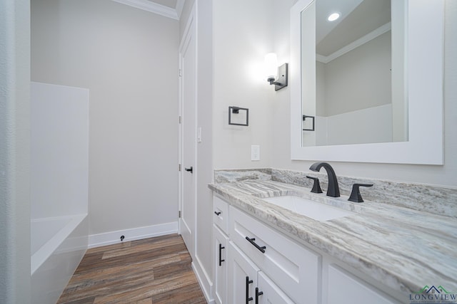 bathroom featuring vanity, crown molding, and wood-type flooring