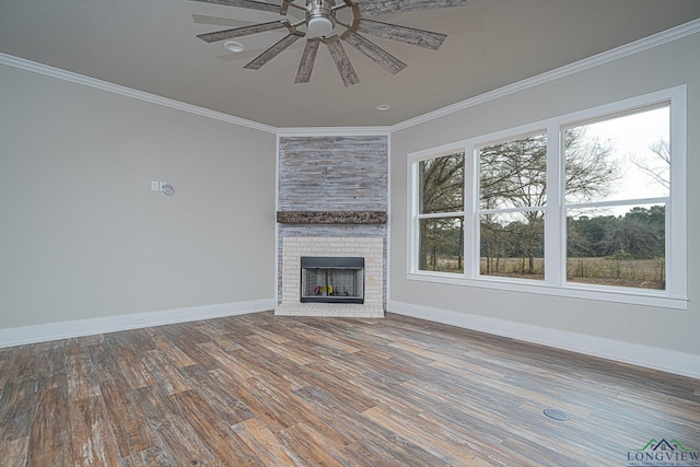 unfurnished living room featuring crown molding, hardwood / wood-style floors, ceiling fan, and a fireplace