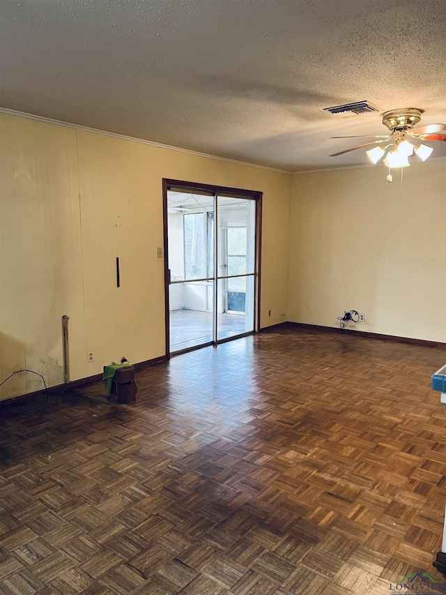 empty room featuring ceiling fan, dark parquet flooring, and a textured ceiling