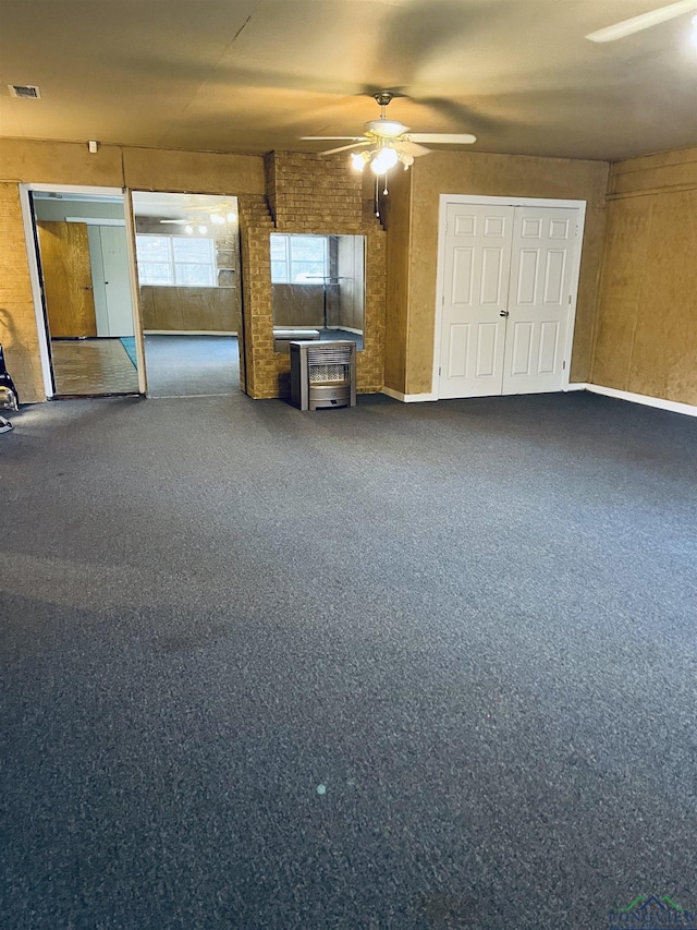 interior space with ceiling fan and dark colored carpet