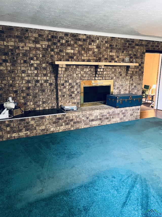 unfurnished living room with crown molding, a fireplace, carpet floors, and a textured ceiling