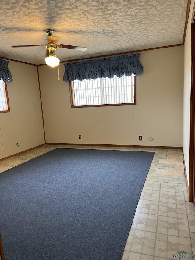 spare room with ornamental molding and ceiling fan