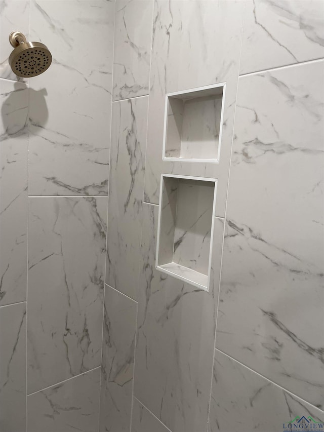 interior details featuring a tile shower