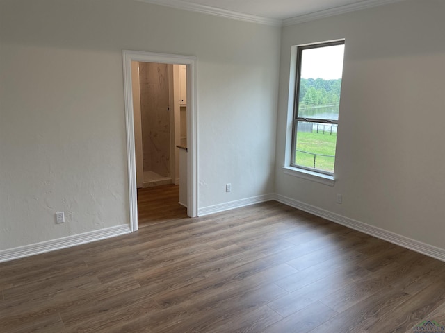 empty room featuring dark hardwood / wood-style flooring and ornamental molding