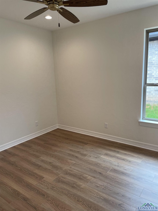 empty room with ceiling fan and dark wood-type flooring