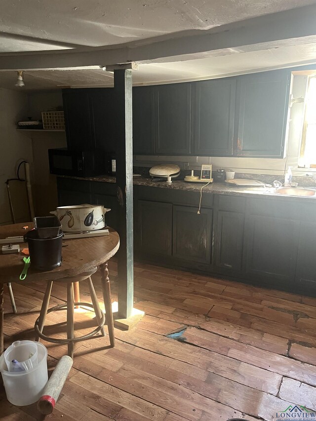 1401 Gay St, Longview, TX 75602 - interior space with black microwave, a sink, and light wood finished floors