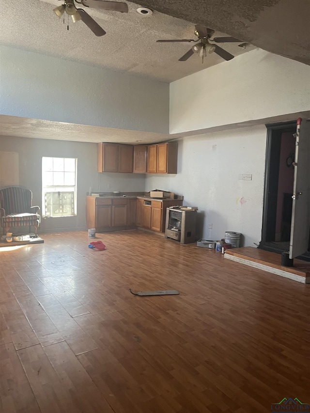 1401 Gay St, Longview, TX 75602 - unfurnished living room with dark wood-type flooring, a textured ceiling, vaulted ceiling, and ceiling fan