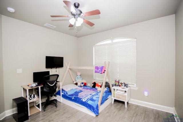 bedroom with ceiling fan, baseboards, visible vents, and wood finished floors