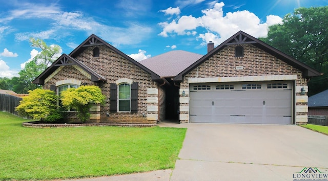 view of front of home with a garage, a front yard, a chimney, brick siding, and concrete driveway