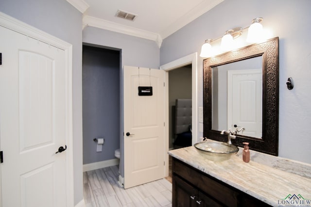 bathroom with crown molding, visible vents, vanity, toilet, and baseboards