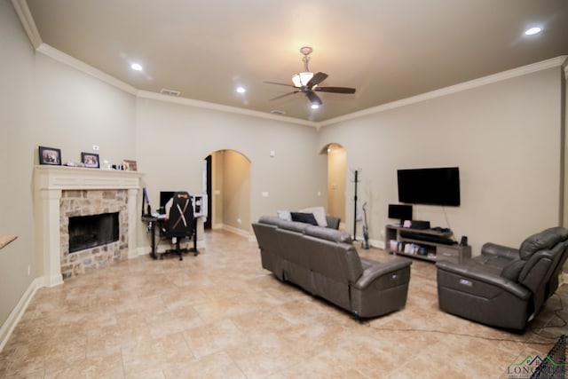 living area featuring arched walkways, ceiling fan, recessed lighting, and a stone fireplace