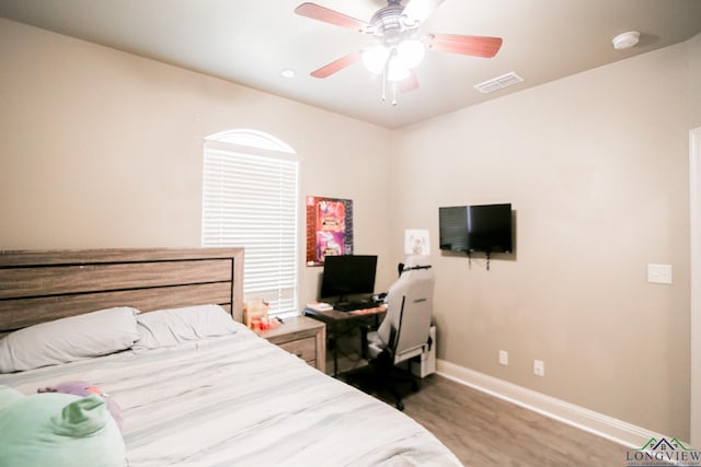 bedroom featuring ceiling fan, baseboards, visible vents, and wood finished floors