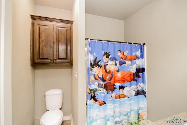bathroom with toilet and a shower with curtain