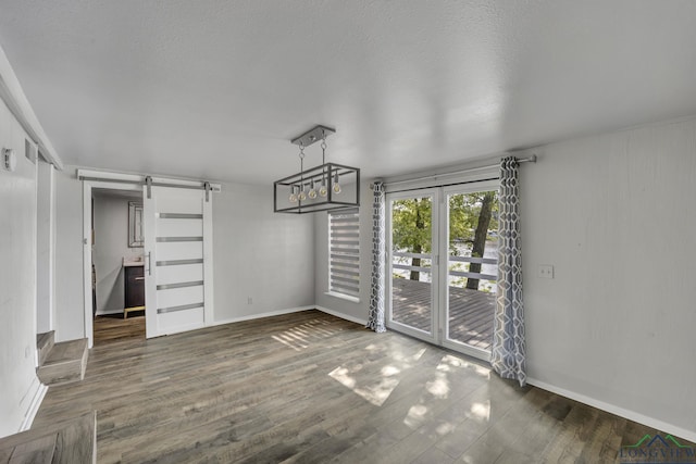 585 Naples Dr, Omaha, TX 75571 - unfurnished dining area with baseboards, a barn door, and wood finished floors