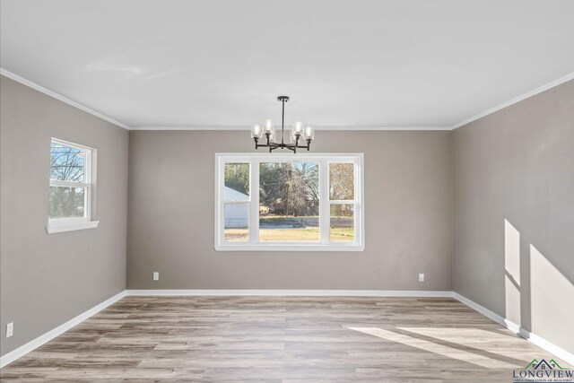2210 E Harold St, Gladewater, TX 75647 - unfurnished dining area with a notable chandelier, baseboards, crown molding, and wood finished floors