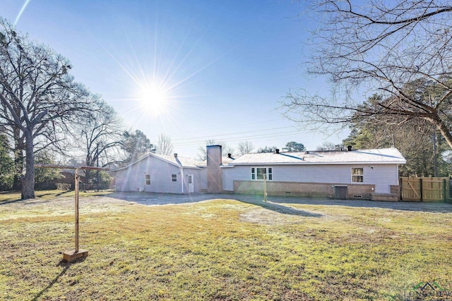 2210 E Harold St, Gladewater, TX 75647 - back of house featuring a yard, central AC unit, fence, and a chimney