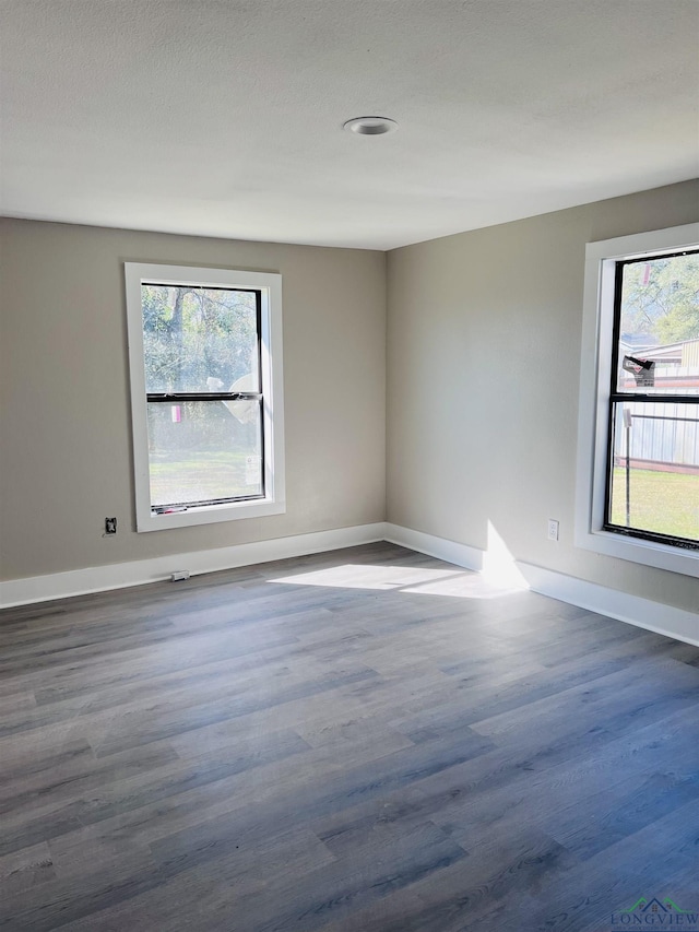 unfurnished room with dark hardwood / wood-style flooring