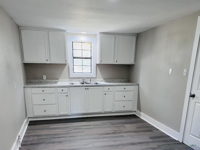 kitchen with dark hardwood / wood-style flooring, white cabinetry, and sink