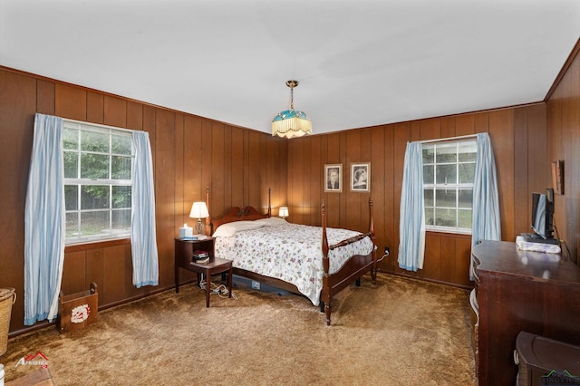 carpeted bedroom featuring wooden walls