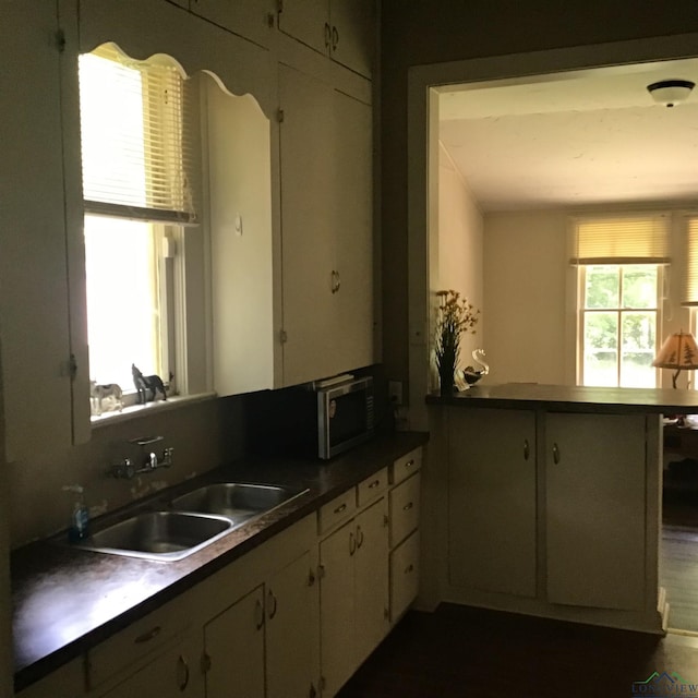 436 S Main St, Longview, TX 75601 - kitchen with white cabinetry, a peninsula, and stainless steel microwave