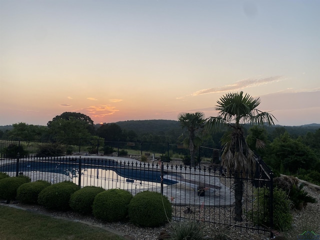 pool at dusk with a patio