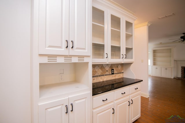 bar featuring decorative backsplash, ceiling fan, dark hardwood / wood-style floors, a fireplace, and white cabinetry