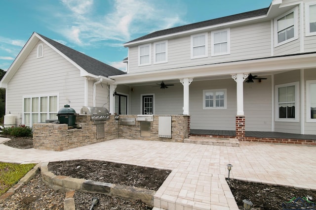 rear view of house featuring ceiling fan, exterior kitchen, and a patio