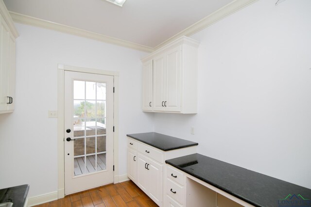 kitchen featuring hardwood / wood-style floors, white cabinetry, and crown molding