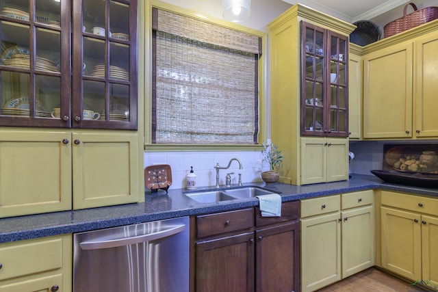 kitchen with decorative backsplash, stainless steel dishwasher, ornamental molding, sink, and cream cabinets