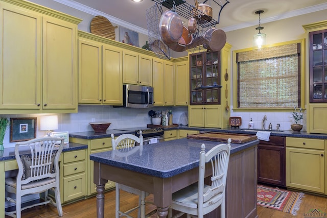 kitchen featuring a center island, sink, range with electric cooktop, tasteful backsplash, and decorative light fixtures