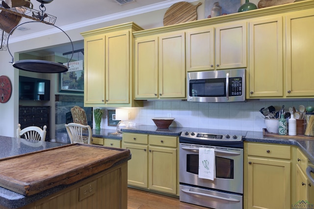 kitchen with backsplash, light hardwood / wood-style flooring, ornamental molding, appliances with stainless steel finishes, and butcher block countertops