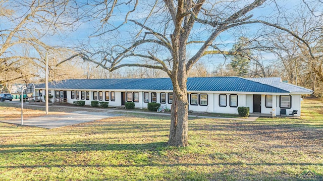 single story home featuring a front lawn