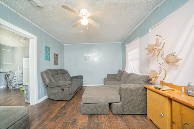 living room with ceiling fan, dark wood-type flooring, a textured ceiling, and ornamental molding