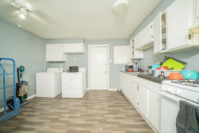 kitchen featuring light wood-type flooring, white cabinetry, white gas stove, and washing machine and clothes dryer