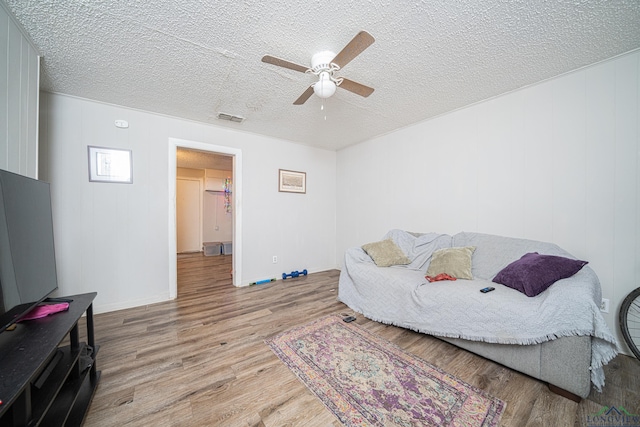 sitting room with a textured ceiling, light hardwood / wood-style floors, and ceiling fan