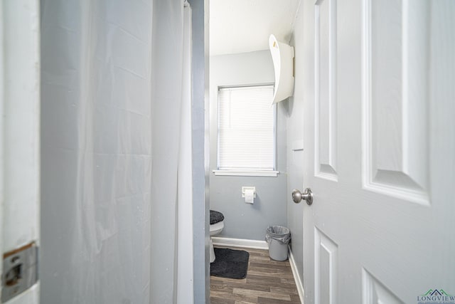 bathroom featuring wood-type flooring and toilet