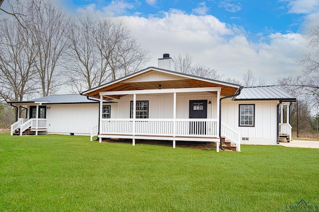 view of front of home featuring metal roof, a front lawn, crawl space, and a chimney