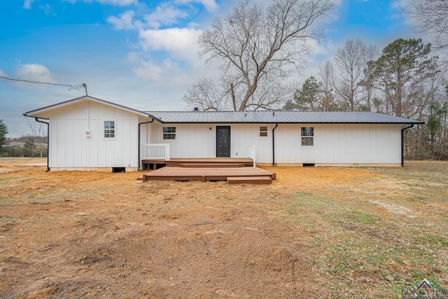 rear view of house featuring a deck, metal roof, and crawl space