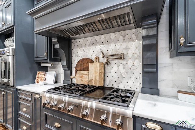 1882 County Road 3000, Joaquin, TX 75954 - kitchen featuring stainless steel gas cooktop, wall chimney exhaust hood, backsplash, and light stone countertops