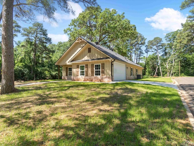 view of front of property with a garage, a front lawn, and cooling unit