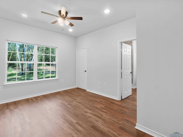 unfurnished room with ceiling fan and dark wood-type flooring