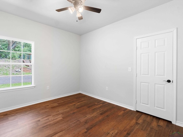 spare room with dark hardwood / wood-style flooring and ceiling fan